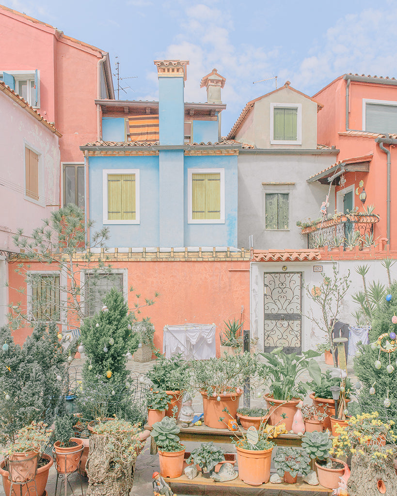 An image of a small garden and some houses, in bright and optimistic hues, by emerging Portuguese artist Teresa Freitas.